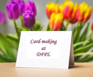 Greeting card in front of purple and orange tulips